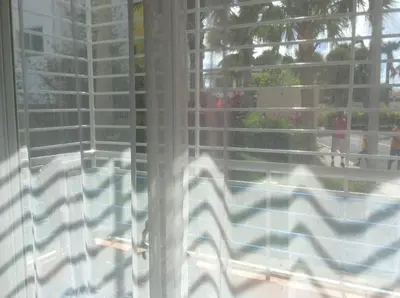 a window with a view of a swimming pool at Oasis Palma Real santiago, Republica Dominicana in Santiago de los Caballeros