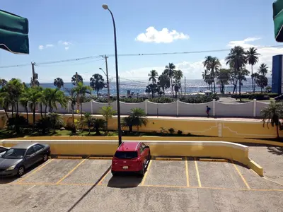 a red van is parked in a parking lot at Caribbean Seaview apart Malecon Santo Domingo in Santo Domingo