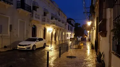 a white car parked on a city street at night at Caribbean Seaview apart Malecon Santo Domingo in Santo Domingo