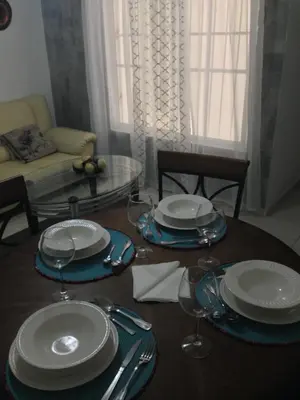 a dining room table with plates and wine glasses at Caribbean Seaview apart Malecon Santo Domingo in Santo Domingo