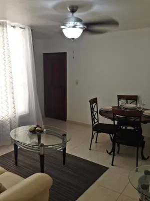 a living room with a table and a ceiling fan at Caribbean Seaview apart Malecon Santo Domingo in Santo Domingo