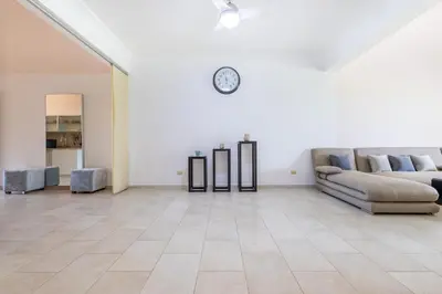 a living room with a couch and a clock on the wall at Private & Luxury Apartment Cocotal in Gated & Secured Community in Punta Cana