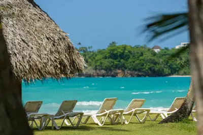 a row of lounge chairs on the beach at Hotel Atlantis in Las Terrenas