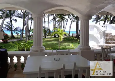 a white table and chairs on a porch overlooking the ocean at Hotel Atlantis in Las Terrenas