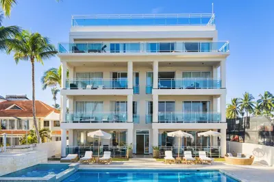 an apartment building with a pool and palm trees at Watermark Luxury Oceanfront Residences in Cabarete