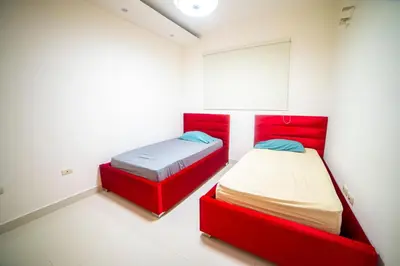 two beds in a room with red dividers at SFMverdana Rental in San Francisco de Macorís