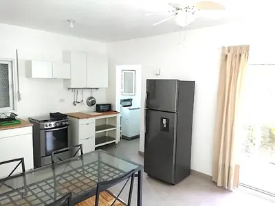 a kitchen with a glass table and a black refrigerator at SolyViento 67 in Cabarete