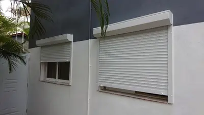 a white building with a window and a shutter at SolyViento 67 in Cabarete