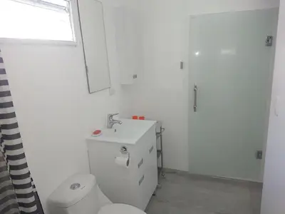 a bathroom with a toilet and a sink and a window at SolyViento 67 in Cabarete