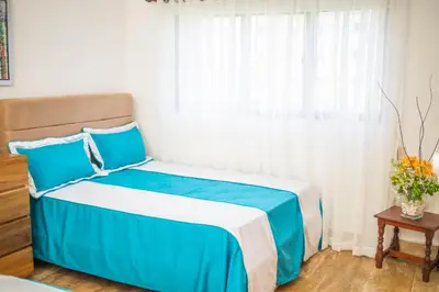 a blue and white bed in a room with a window at Monserrat Residences in Las Terrenas