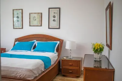 a bedroom with a bed with blue pillows and a table at Monserrat Residences in Las Terrenas