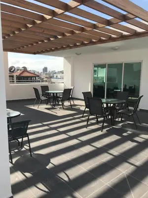 a patio with tables and chairs on a roof at Cozy apartment in exclusive area Bella Vista in Santo Domingo
