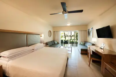 a bedroom with a bed and a desk and a couch at Occidental Punta Cana - All Inclusive in Punta Cana