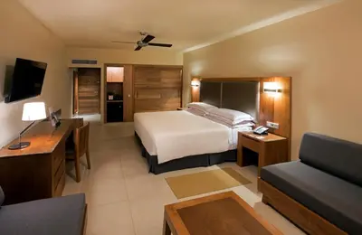 a hotel room with a bed and a couch at Occidental Punta Cana - All Inclusive in Punta Cana