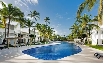 a pool at the resort with palm trees at Occidental Punta Cana - All Inclusive in Punta Cana