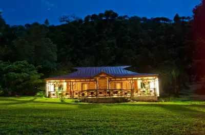 a log cabin in a grassy field at night at Platon Ecolodge in Santa Cruz de Barahona