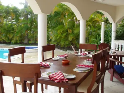a wooden table with plates of food on a porch at 3br Villa with Vip Access - All Inclusive Program with Alcohol Included in San Felipe de Puerto Plata