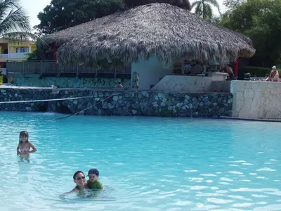 a woman and two children swimming in a swimming pool at 3br Villa with Vip Access - All Inclusive Program with Alcohol Included in San Felipe de Puerto Plata