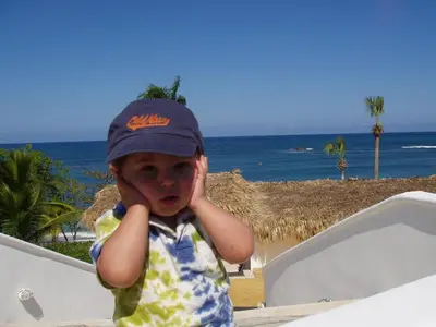 a young boy wearing a hat on the beach at 3br Villa with Vip Access - All Inclusive Program with Alcohol Included in San Felipe de Puerto Plata