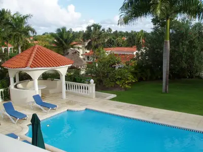 a swimming pool with chairs and a gazebo at 3br Villa with Vip Access - All Inclusive Program with Alcohol Included in San Felipe de Puerto Plata