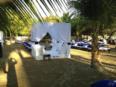 a group of beds under a tent under a palm tree at Junior Suite in Puerto Plata at Lifestyle Holidays Vacation Club in San Felipe de Puerto Plata