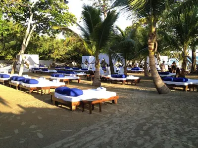 a row of tables and chairs on a beach with palm trees at Junior Suite in Puerto Plata at Lifestyle Holidays Vacation Club in San Felipe de Puerto Plata