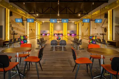 a bowling alley with ping pong tables and chairs at Ocean el Faro Resort - All Inclusive in Punta Cana