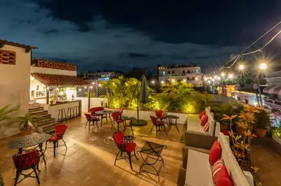 a rooftop patio with tables and chairs at night at El Beaterio Casa Museo in Santo Domingo