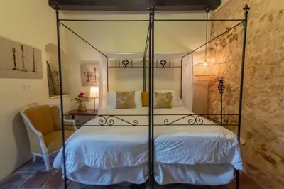 a bedroom with a canopy bed and a chair at El Beaterio Casa Museo in Santo Domingo