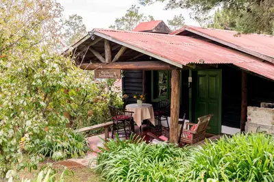a house with a table and chairs in front of it at Villa Pajon Eco Lodge in Constanza