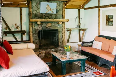 a living room with a fireplace and a couch at Villa Pajon Eco Lodge in Constanza