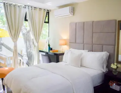 a bedroom with a large white bed and a window at Hotel Santa Clara in San Fernando de Monte Cristi