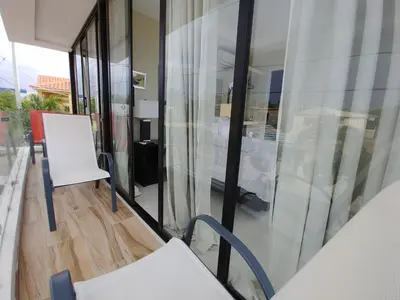 a room with a white chair and a glass wall at Hotel Santa Clara in San Fernando de Monte Cristi