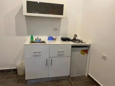 a small white kitchen with a sink and a counter at Apartamentos Magallanes Bayahibe in Bayahibe
