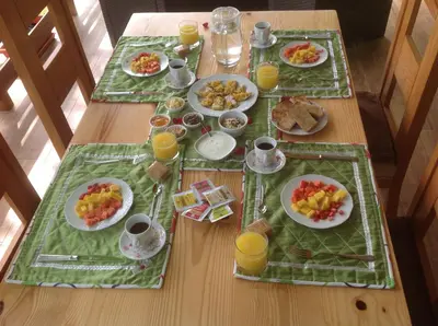a wooden table with plates of food and orange juice at Mi Hogar Jarabacoa in Jarabacoa