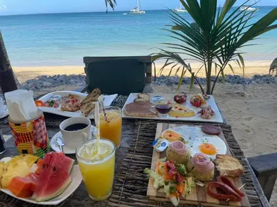 a table with breakfast foods and drinks on the beach at Afreeka Beach Hotel in Las Terrenas