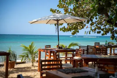 a table with an umbrella on the beach at Afreeka Beach Hotel in Las Terrenas
