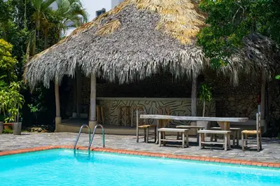 a hut with a table and chairs next to a swimming pool at Afreeka Beach Hotel in Las Terrenas