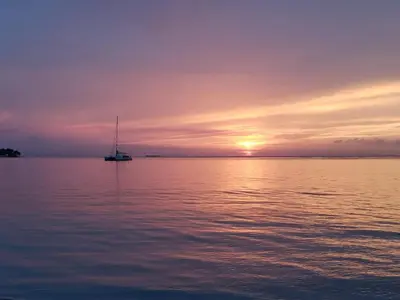 a sailboat on the water at sunset at Las Terrenas, La Fenice, Playa Popy in Las Terrenas