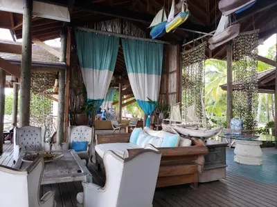 a bedroom in a resort with a bed and chairs at Las Terrenas, La Fenice, Playa Popy in Las Terrenas