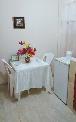a white table with a vase of flowers on it at Apartahotel carla in Boca Chica
