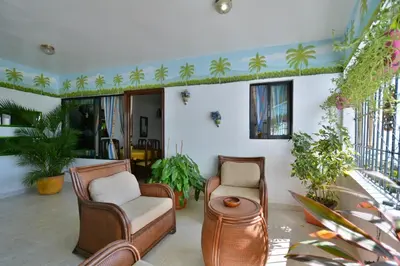 a living room with two chairs and a table at Villa Alégria in Santa Bárbara de Samaná