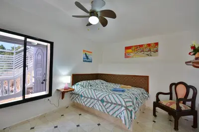 a bedroom with a bed and a window and a fan at Villa Alégria in Santa Bárbara de Samaná