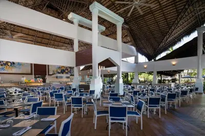 a restaurant with tables and chairs in a building at Impressive Punta Cana - All Inclusive in Punta Cana
