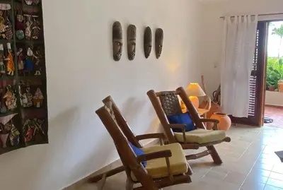 a room with three rocking chairs and pictures on the wall at Cabarete Beachfront Condos at Nanny Estate C-5 in Cabarete