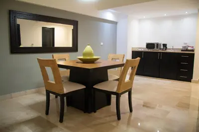 a dining room table with chairs and a mirror at Radisson Hotel Santo Domingo in Santo Domingo