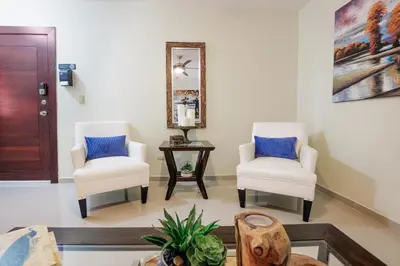 a living room with two chairs and a table at Dolce Villas at Harmony 2 in Santiago de los Caballeros
