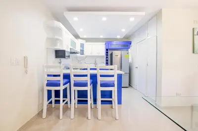a kitchen with white walls and blue stools at Dolce Villas at Harmony 2 in Santiago de los Caballeros