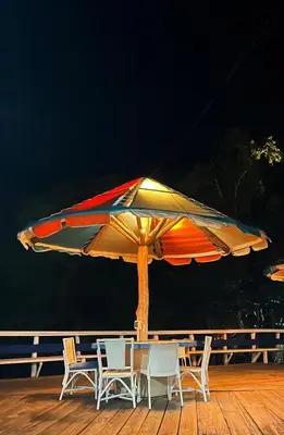 a table and chairs under an umbrella on a deck at Puerto Blanco Marina & Hotel in Puerto de Luperon