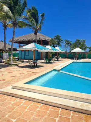 a swimming pool with umbrellas and a resort at Puerto Blanco Marina & Hotel in Puerto de Luperon
